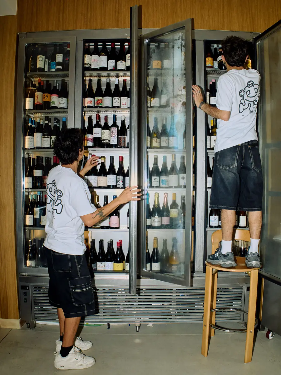 Dos cambrers trien vins a la nevera del Bar Amicks