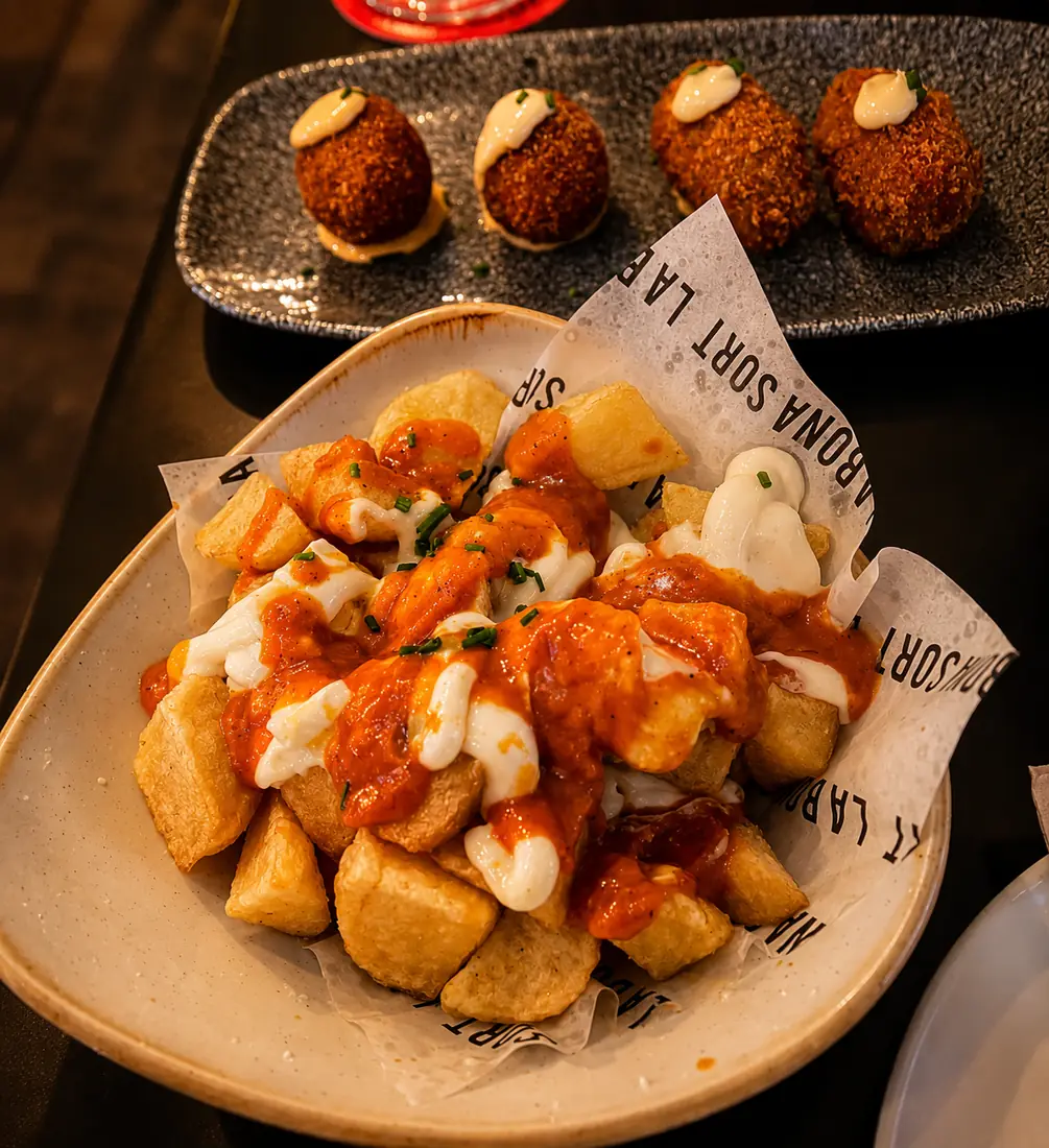 Patates braves en primer pla i croquetes casolanes al darrere