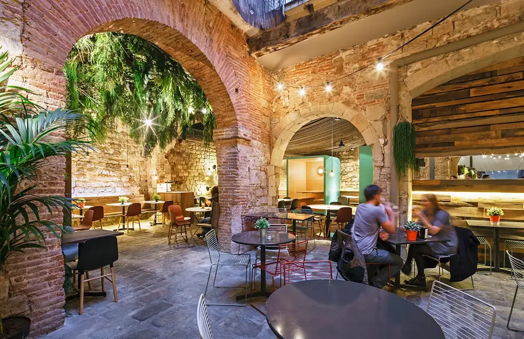 Els arcs de la terrassa, amb plantes penjant i taules ocupades