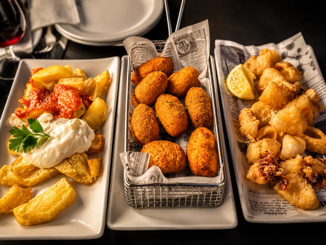 Tres tapes de la casa: braves, croquetes i calamars
