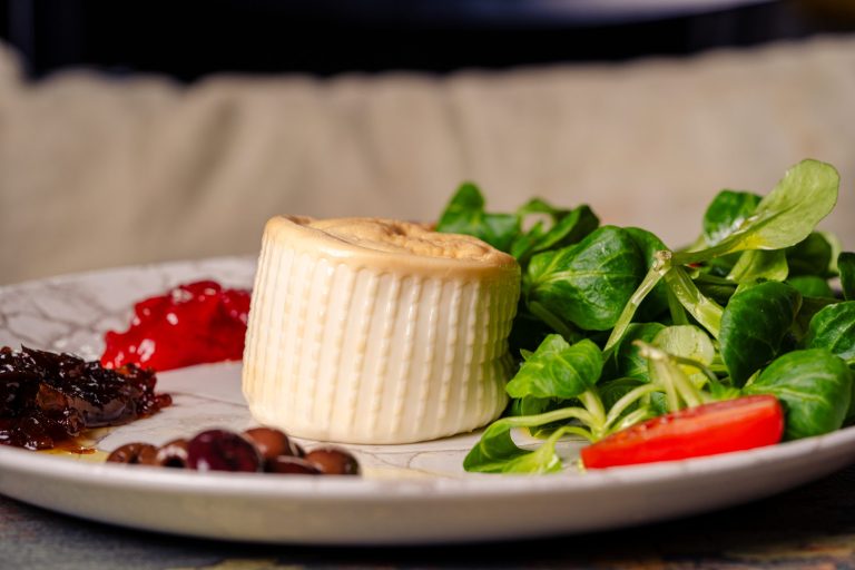 Burrata affumicata su letto di valeriana con pomodoro e cipolla caramellizzato e olive taggiasche