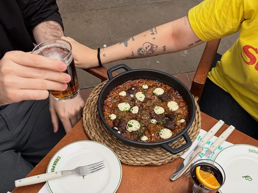 Cazuela de arroz en el centro de la mesa, con cervezas alrededor