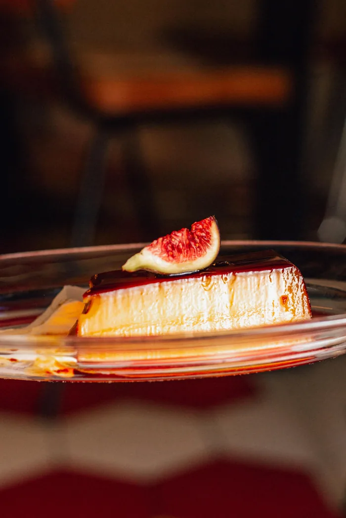 Una porción de flan con caramelo y medio higo
