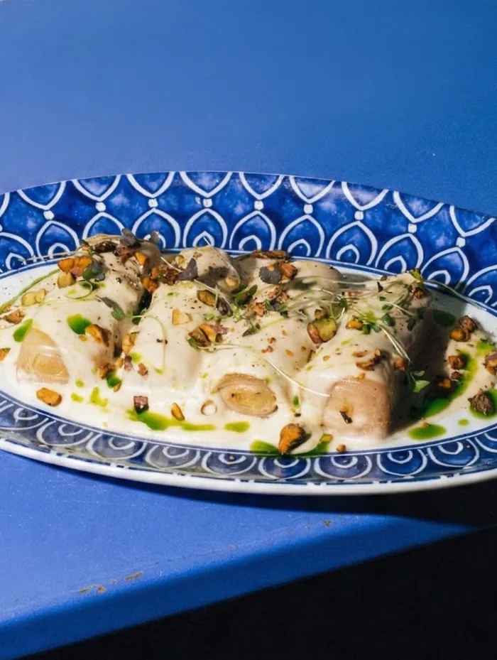 Puerro confitado con crema de cebolla y patata y pistacho