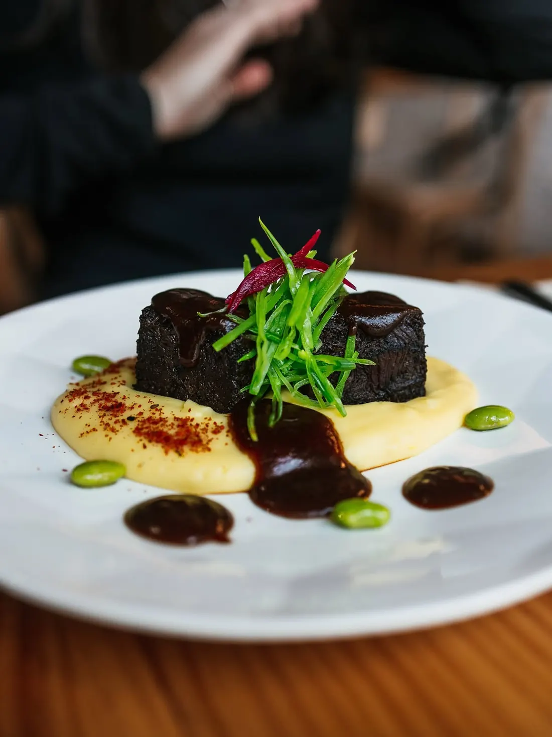 Carrillera de ternera glaseada sobre puré, con cebollino y salsa