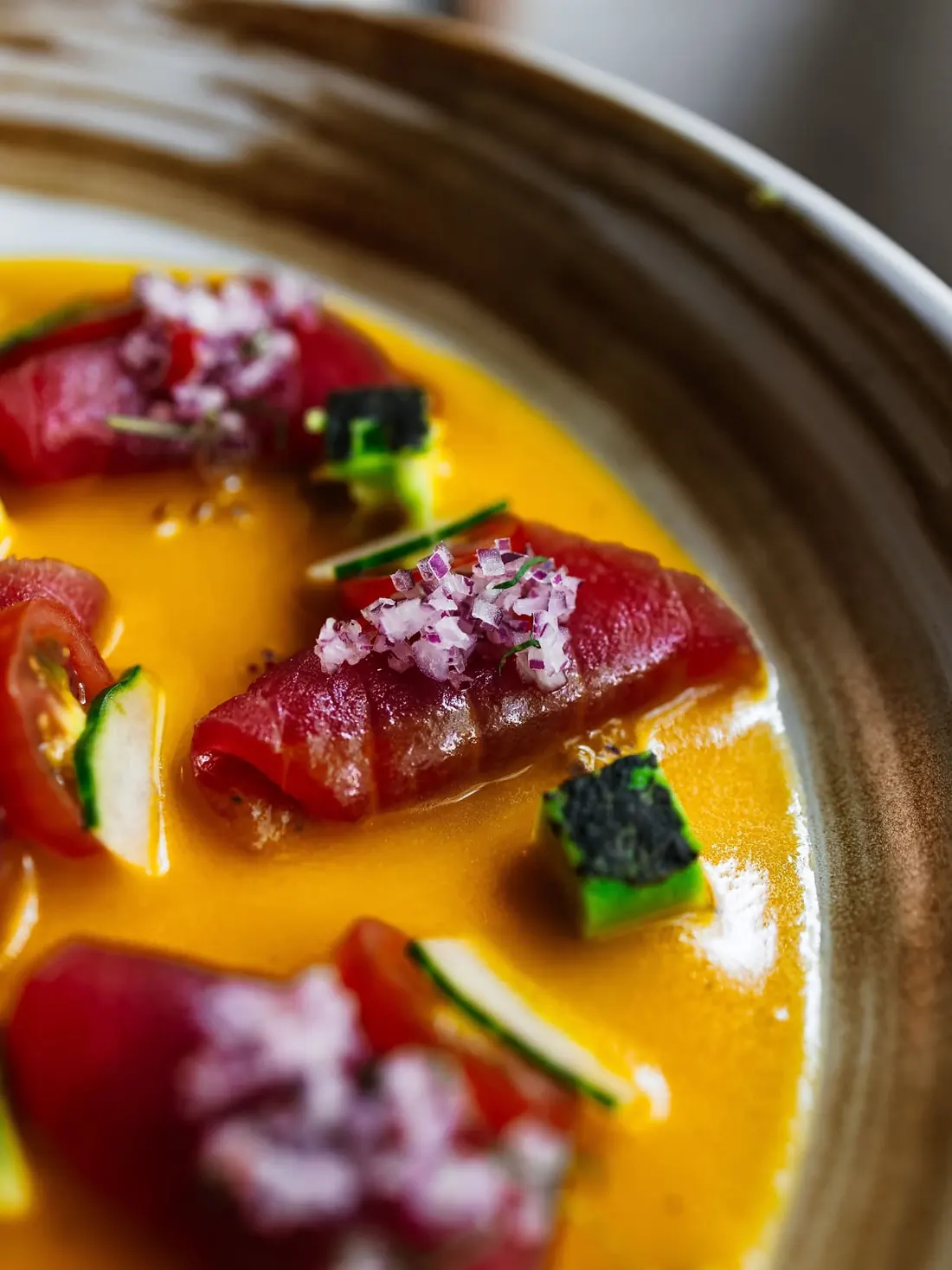 Tiradito de atún en salsa de ají amarillo, con cebolla morada y pepino