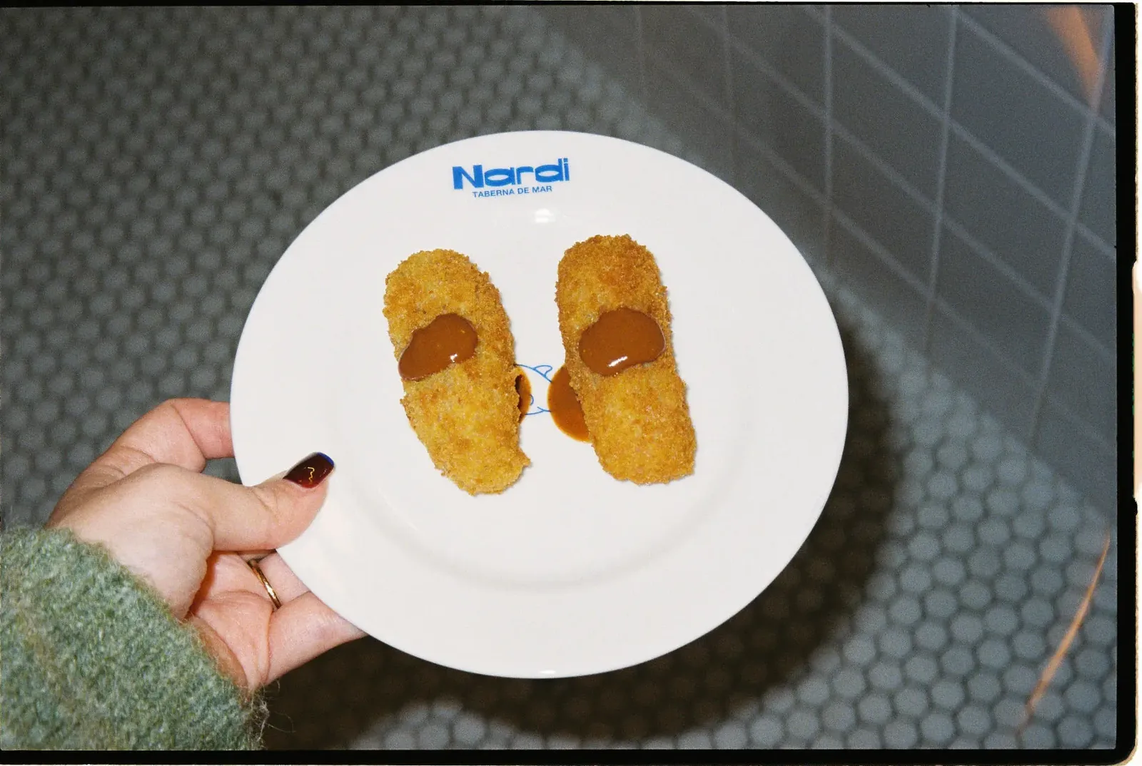 Dos croquetas doradas con un toque de salsa, en un plato de Nardi