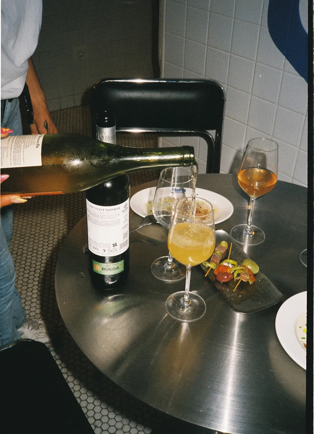 Sirven vino en la mesa, junto a una gilda