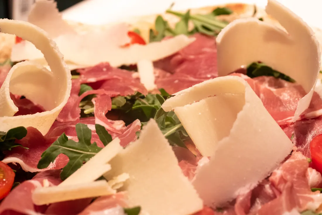 Jamón crudo con lascas de parmesano y rúcula, de cerca