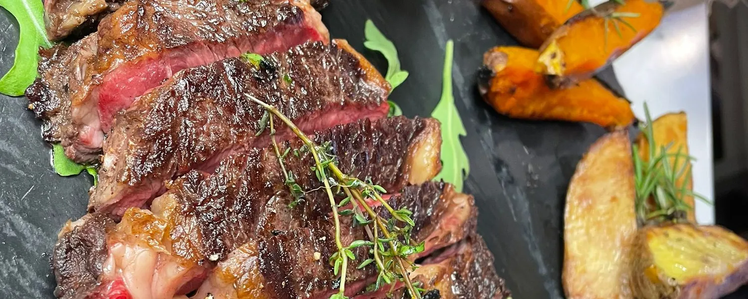 Carne a la brasa en lonchas, con zanahorias y patatas asadas